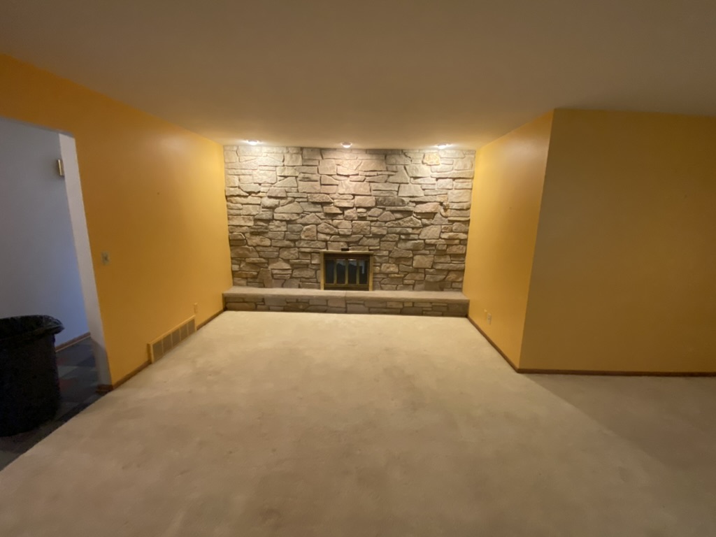 Basement with stone fireplace wall completely cleared after cleanout