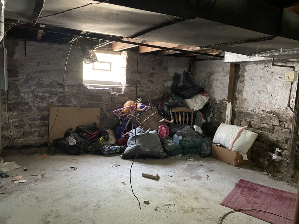 Old basement with bags and debris before cleanout