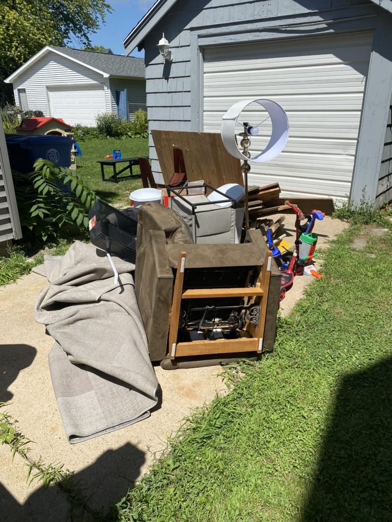 Junk pile by garage ready for pickup in Oshkosh WI
