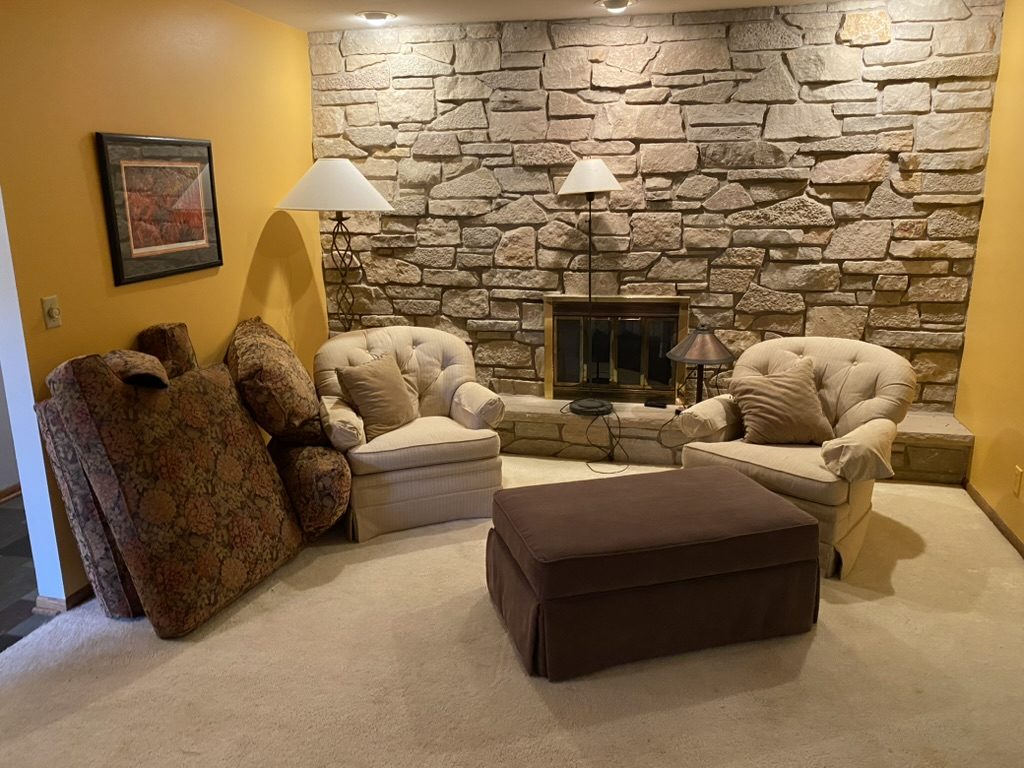 Living room furniture removal before shot - couches and chairs by fireplace