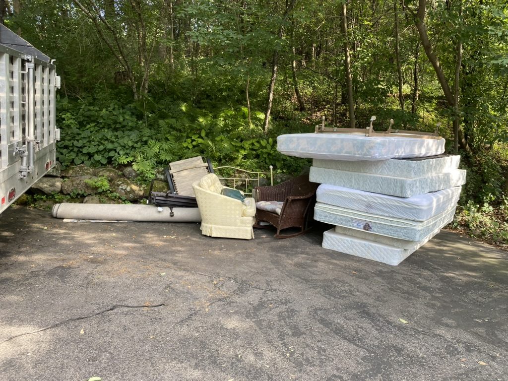 Mattresses and furniture staged for pickup by Clear The Clutter